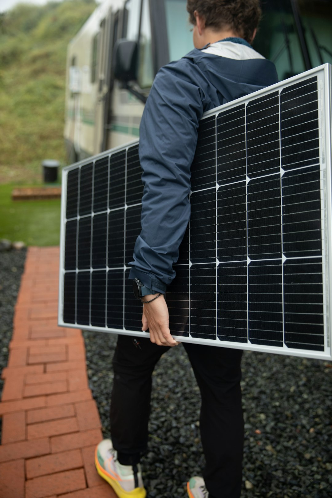 who-we-are a-man-carrying-a-solar-panel-on-his-back-0jf8n9cog6s